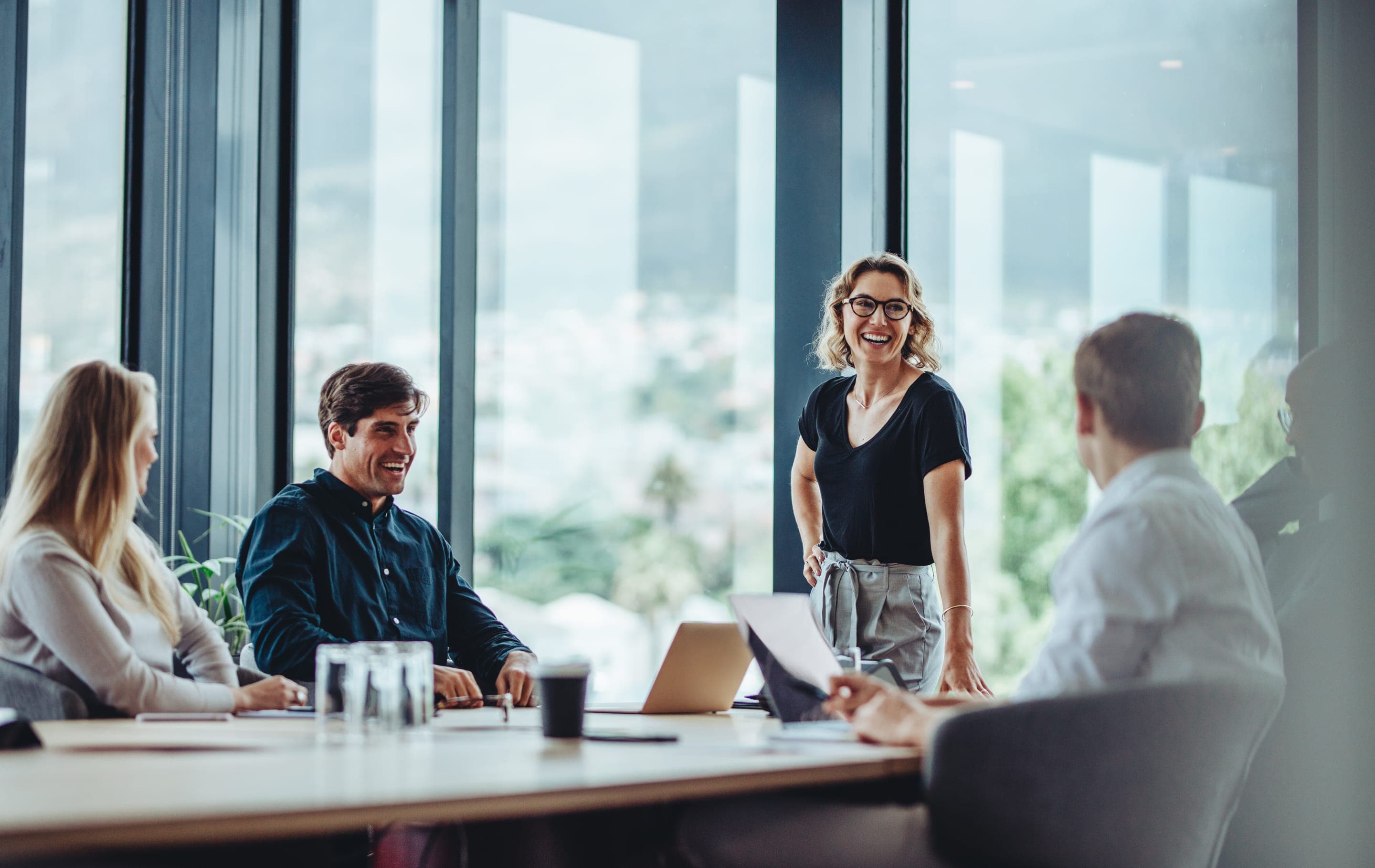 Colleagues in a meeting around a table in a bright office.
